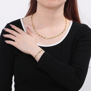 Détail de l'ensemble collier et bracelet à maillons en forme de cœur dorés sur un mannequin
