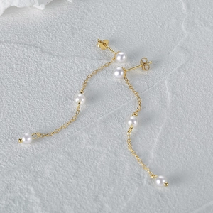 Detailed macro view of S925 sterling silver chain earrings with lustrous white pearls