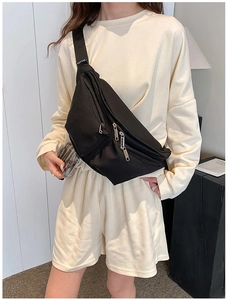 Detail of black nylon multi-pocket crossbody bag with adjustable wide strap and zipper