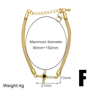Detailed view of gold cross bracelet with black heart stone and size measurements