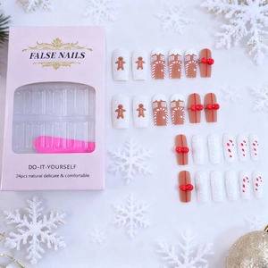 Christmas press-on nails set with 3D gingerbread man, red bows, and white snowflakes