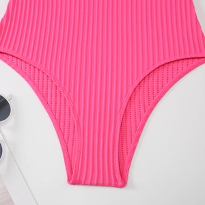 Dettaglio del tessuto a costine rosso rosa del costume con cuciture pulite e taglio alto