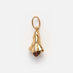 Detailed view of bell-shaped gold pendant with a deep red December birthstone inlay