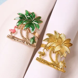Detail of gold napkin rings featuring tropical flamingo and palm tree enamel designs