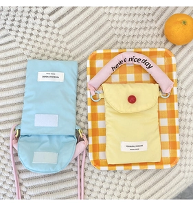 Detail view of Korean canvas phone bags in blue and yellow with embroidered handle