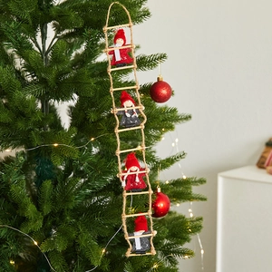 Christmas ladder ornament with four Santa dolls hanging on a decorated festive pine tree