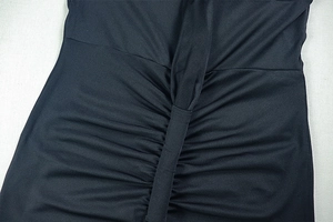 Detailed view of sophisticated ruched draping on a black backless cocktail party dress