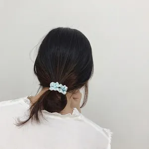 Pale blue satin scrunchie shown on hair, minimalist light blue ponytail hair tie for women