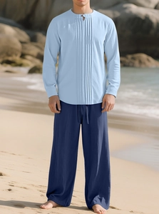 Ensemble chemise en lin bleu ciel et pantalon bleu marine dans un décor de plage