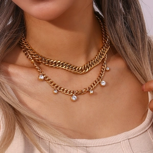 Close-up of gold plated layered necklace set with chunky chain and rhinestone pendant