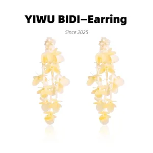 Macro shot of sparkling beige floral tassel earrings with translucent petal clusters