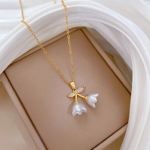 Elegant gold titanium necklace featuring double lily of the valley pendants with crystal inlay