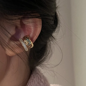 Detail of gold ear cuff set with hammered metal texture and shimmering crystals