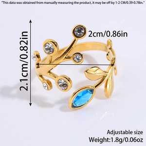 Detail view of adjustable gold titanium ring with blue gemstone and wheat ear leaf patterns