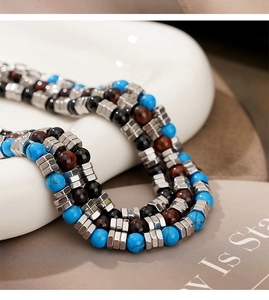 Macro detail of blue turquoise, brown tiger eye stone beads and silver metal spacers