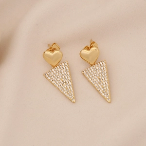 Vue macro de boucles d'oreilles cœur et triangle géométrique en or avec zircons