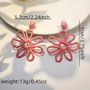 Detailed view of pink woven raffia flower earrings with 7cm height and 5.7cm width