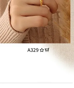 Close-up of a golden braided ring on finger styled with a beige knit sweater