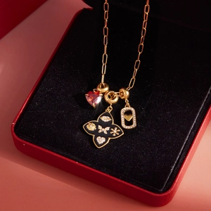 Detailansicht der Goldhalskette mit rotem Herz und Kleeblattanhängern in roter Geschenkbox