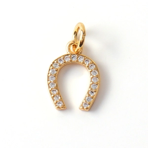 Detailed view of a gold-plated horseshoe pendant with sparkling zircon stone inlays