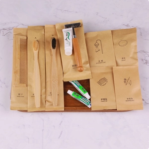 Eco-friendly hotel amenities set with bamboo comb and toothbrushes on wooden tray