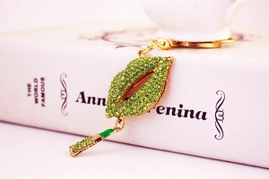 Detail of green rhinestone lips keychain with gold plating and lipstick pendant charm