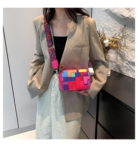 Detail of colorful geometric block crossbody bag with ethnic patterned wide strap
