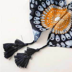 Detail of blue and orange ethnic pattern scarf with dense fringe tassels on edges