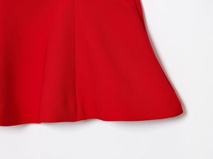 Close-up of the red hemline stitching and fabric texture on a camisole top