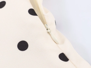 Détail de la fermeture éclair invisible sur la robe beige à pois et texture du tissu