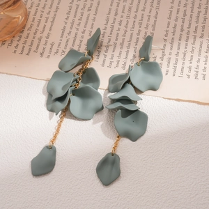 Detail of matte sage green petal drop earrings with gold chain on vintage paper