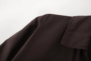 Detailed close-up of collar and shoulder stitching on a dark coffee cotton poplin shirt