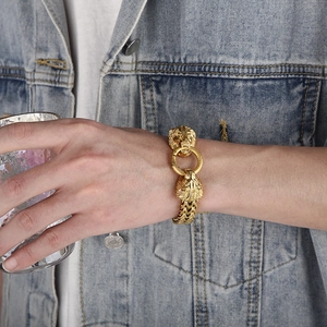 Close-up of a gold-tone hip-hop lion head bracelet on a male model wrist