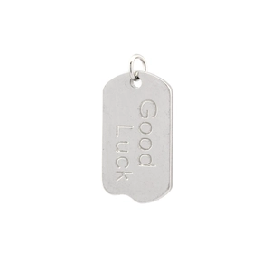 Detailed view of silver rectangular metal pendant with Good Luck engraving for DIY jewelry