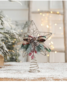 Macro detail of a golden wire Christmas tree topper star with pine cones and red berries