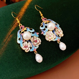 Vintage enamel flower earrings with pearls and pink crystals on dark green velvet background