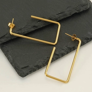 Minimalist gold geometric rectangular stainless steel earrings on a natural slate stone