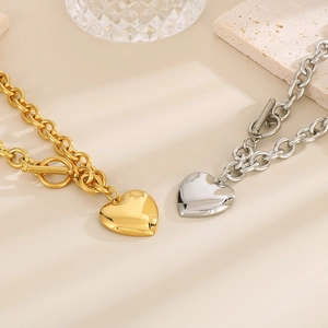 Detail of gold and silver stainless steel heart necklaces with OT toggle clasps on stone