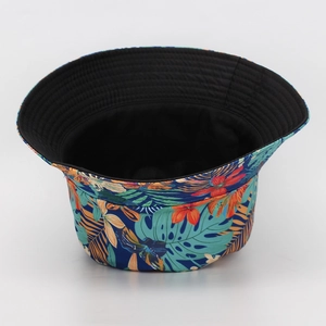 Close-up of reversible bucket hat with tropical leaf print and black interior side