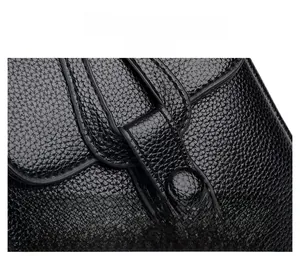 Close-up of black litchi grain leather showing precise stitching and round button detail