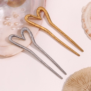 Detail of heart-shaped U-shaped hair pins with hammered gold and silver texture finish