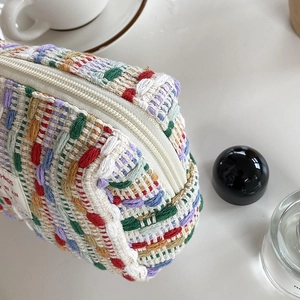 Macro view of colorful woven texture and fabric label on large makeup storage bag