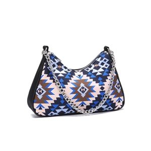 Detail of bohemian geometric pattern fabric and decorative silver chain on underarm bag