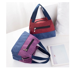 Detail of oxford fabric lunch bags with reinforced handles and front zipper pocket