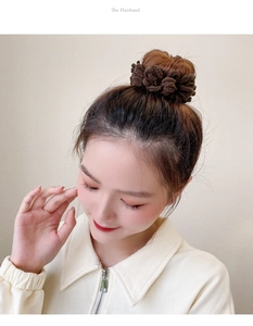 Detail of soft coffee brown plush scrunchie worn on a bun hairstyle for winter