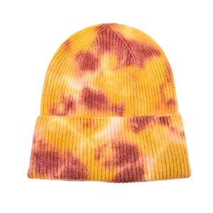 Detailed close-up of warm-toned tie-dye knit beanie with thick fold-over cuff design