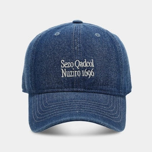 Detailed close-up of dark blue denim baseball cap featuring white Sezo embroidered lettering