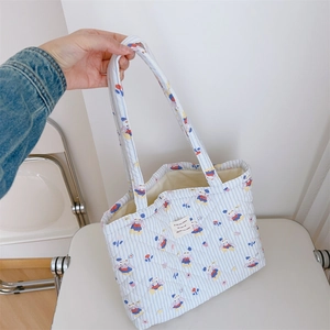 Nahaufnahme der gesteppten Baumwolltasche mit blauem Tiermotiv und gewebtem Etikett