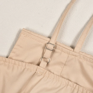 Detailed close-up of khaki twill fabric shoulder strap with silver metal adjuster buckle