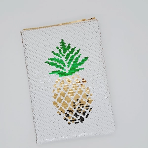 Dettaglio di paillettes reversibili con motivo a ananas su un quaderno per il fai da te